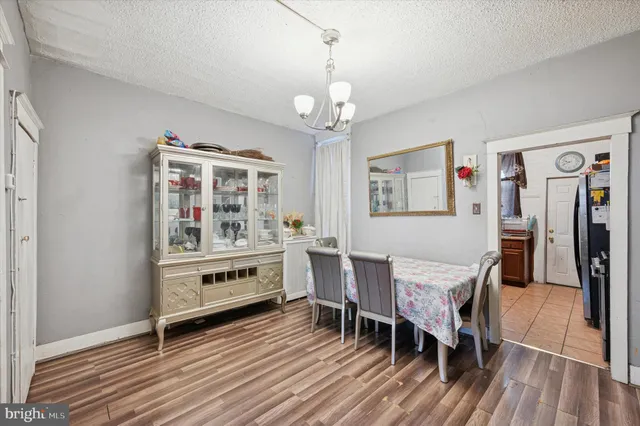 a kitchen with stainless steel appliances a dining table chairs and wooden floor