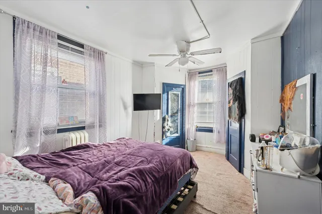 a bedroom with a large bed flat screen tv and a large mirror