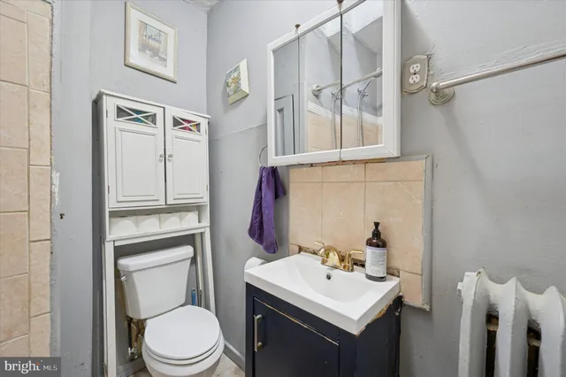 a bathroom with a toilet sink and mirror