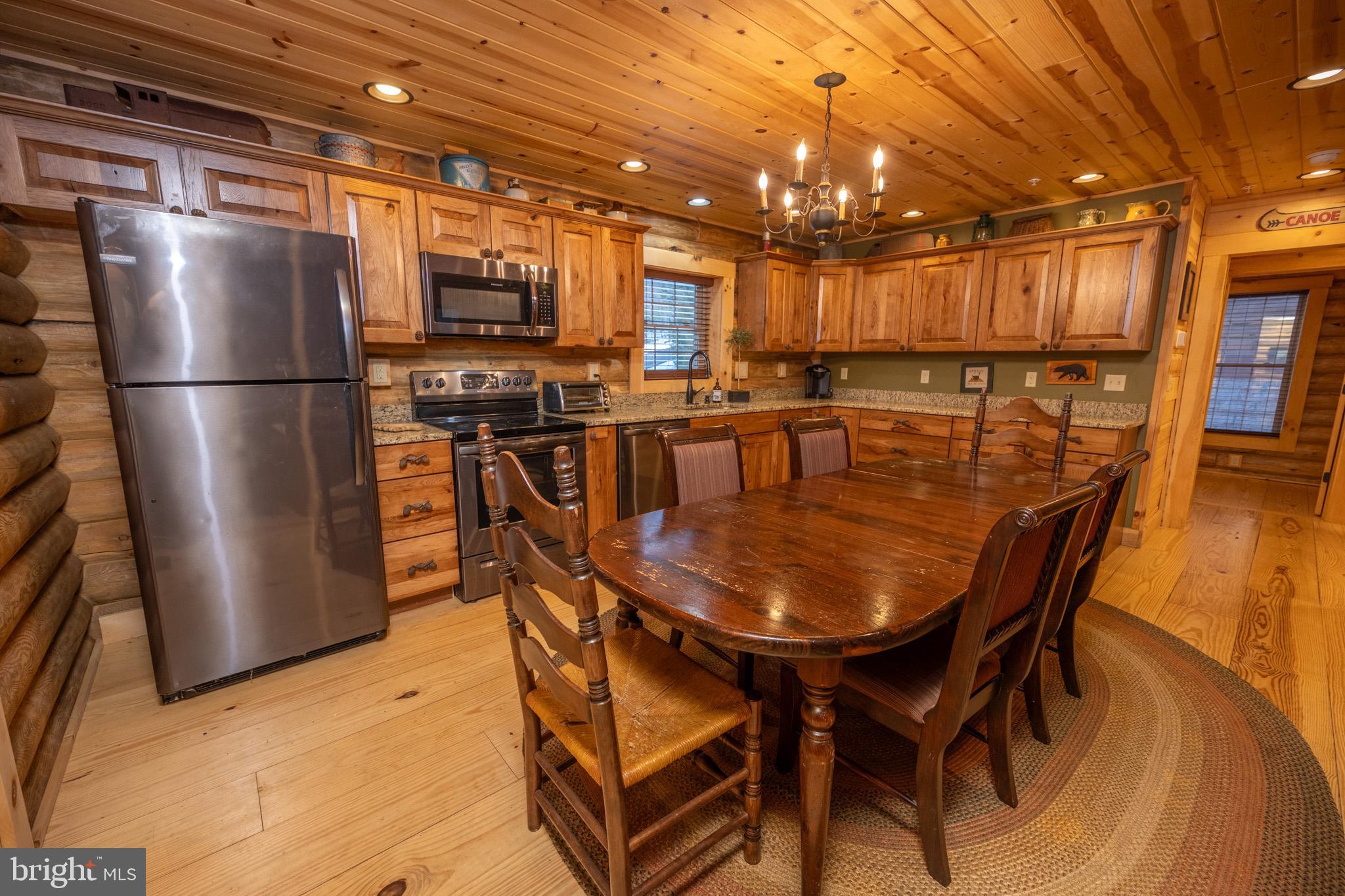 88 Gravelly Run Road McHenry, MD 21541 - Photo 21 of 79 a kitchen with stainless steel appliances granite countertop a dining table chairs refrigerator and microwave