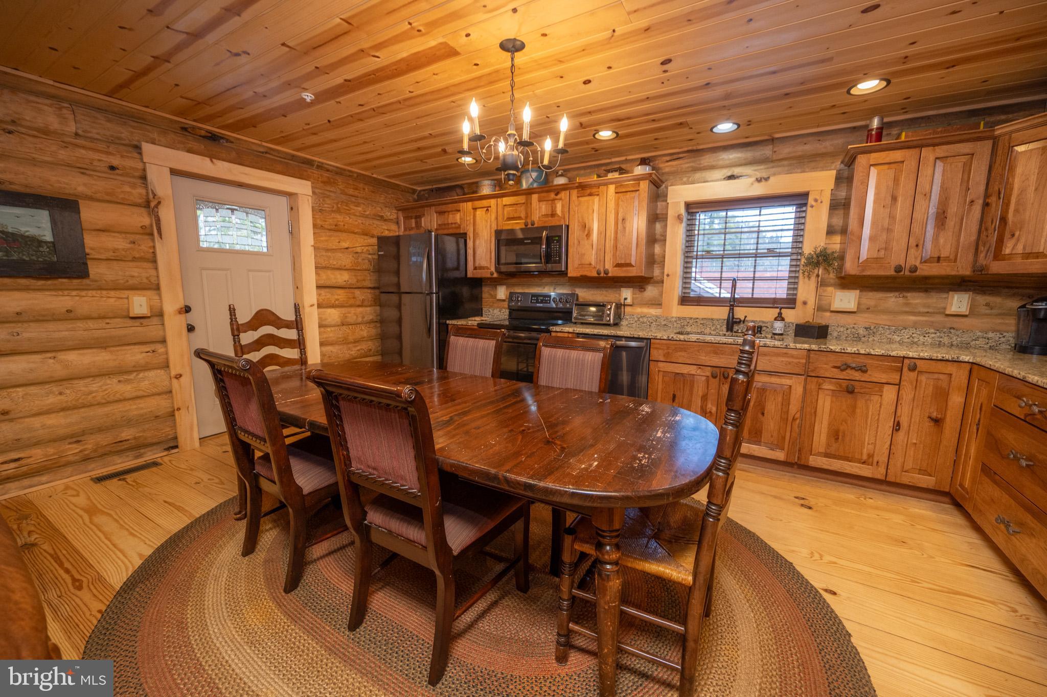 88 Gravelly Run Road McHenry, MD 21541 - Photo 26 of 79 a dining hall with stainless steel appliances granite countertop a stove a sink a dining table and chairs with wooden floor