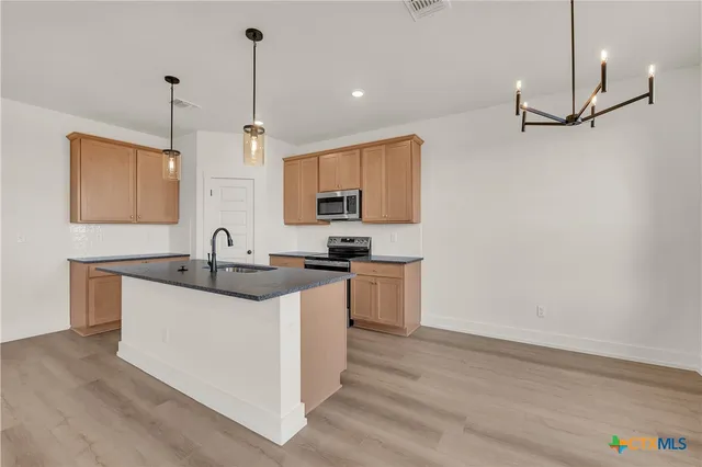a kitchen with stainless steel appliances granite countertop a sink stove and refrigerator
