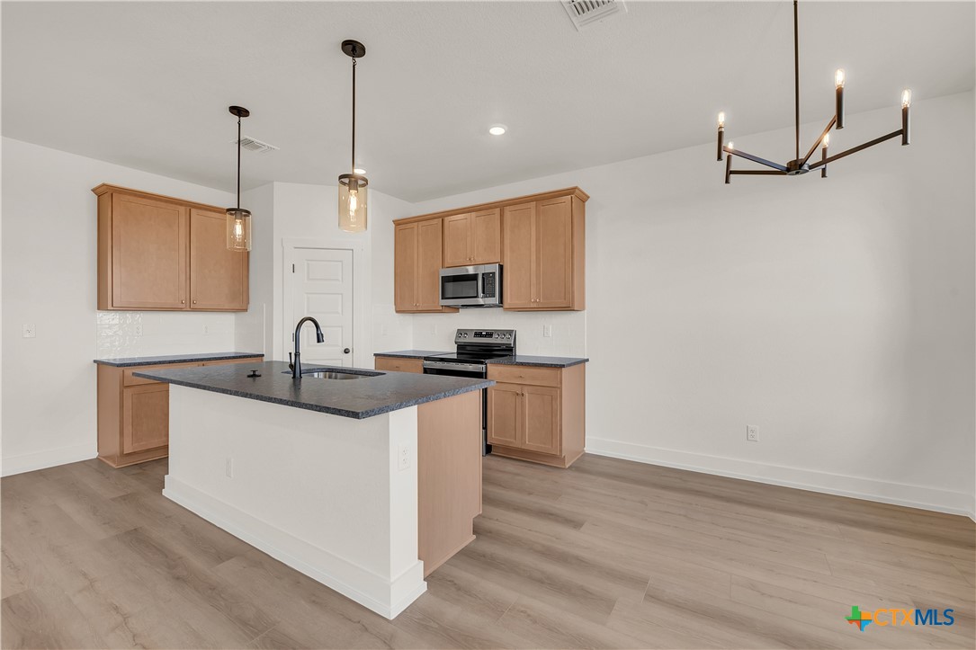 8909 Ponderosa Pine Road Temple, TX 76502 - Photo 4 of 16 a kitchen with stainless steel appliances granite countertop a sink stove and refrigerator