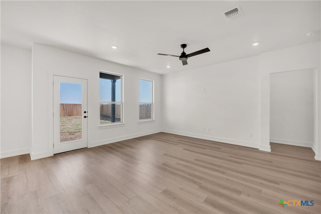 8909 Ponderosa Pine Road Temple, TX 76502 - Photo 7 of 16 a view of an empty room with wooden floor and a window