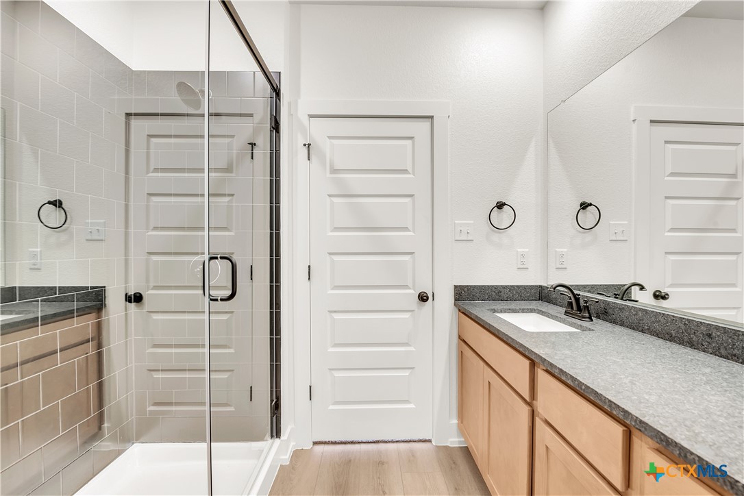 8909 Ponderosa Pine Road Temple, TX 76502 - Photo 9 of 16 a bathroom with a granite countertop sink a mirror and a shower