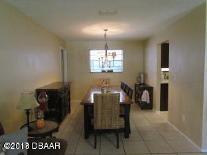 99 Mayfield Circle Ormond Beach, FL 32174 - Photo 12 of 28 a view of a dining room with furniture and chandelier