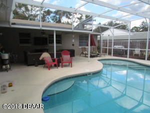 99 Mayfield Circle Ormond Beach, FL 32174 - Photo 22 of 28 a view of a patio with table and chairs potted plants with floor to ceiling window