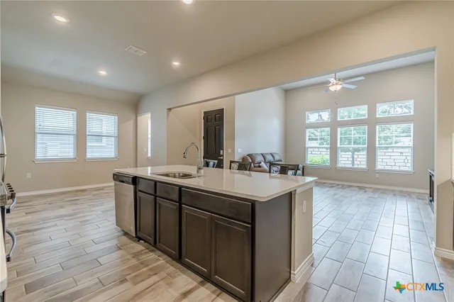 a large kitchen with stainless steel appliances granite countertop a sink and a stove