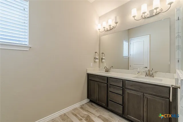 a bathroom with a double vanity sink and a mirror