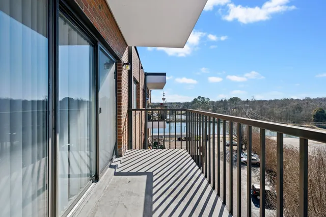 a view of a balcony with wooden floor and fence