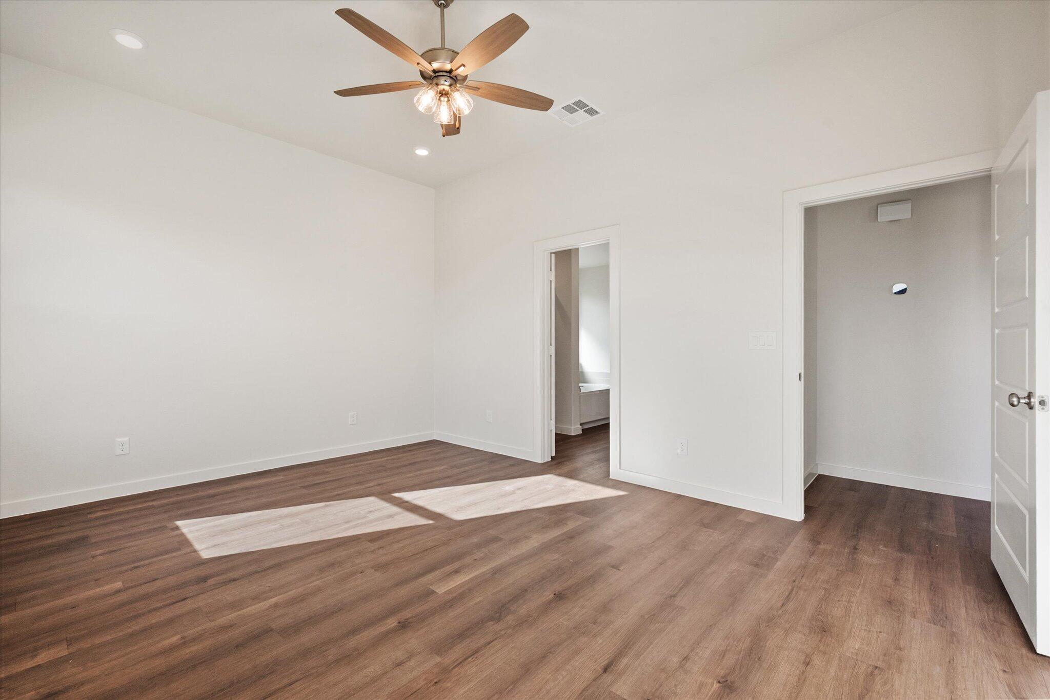 7207 7th Street Lubbock, TX 79416 - Photo 11 of 22 an empty room with wooden floor and a ceiling fan