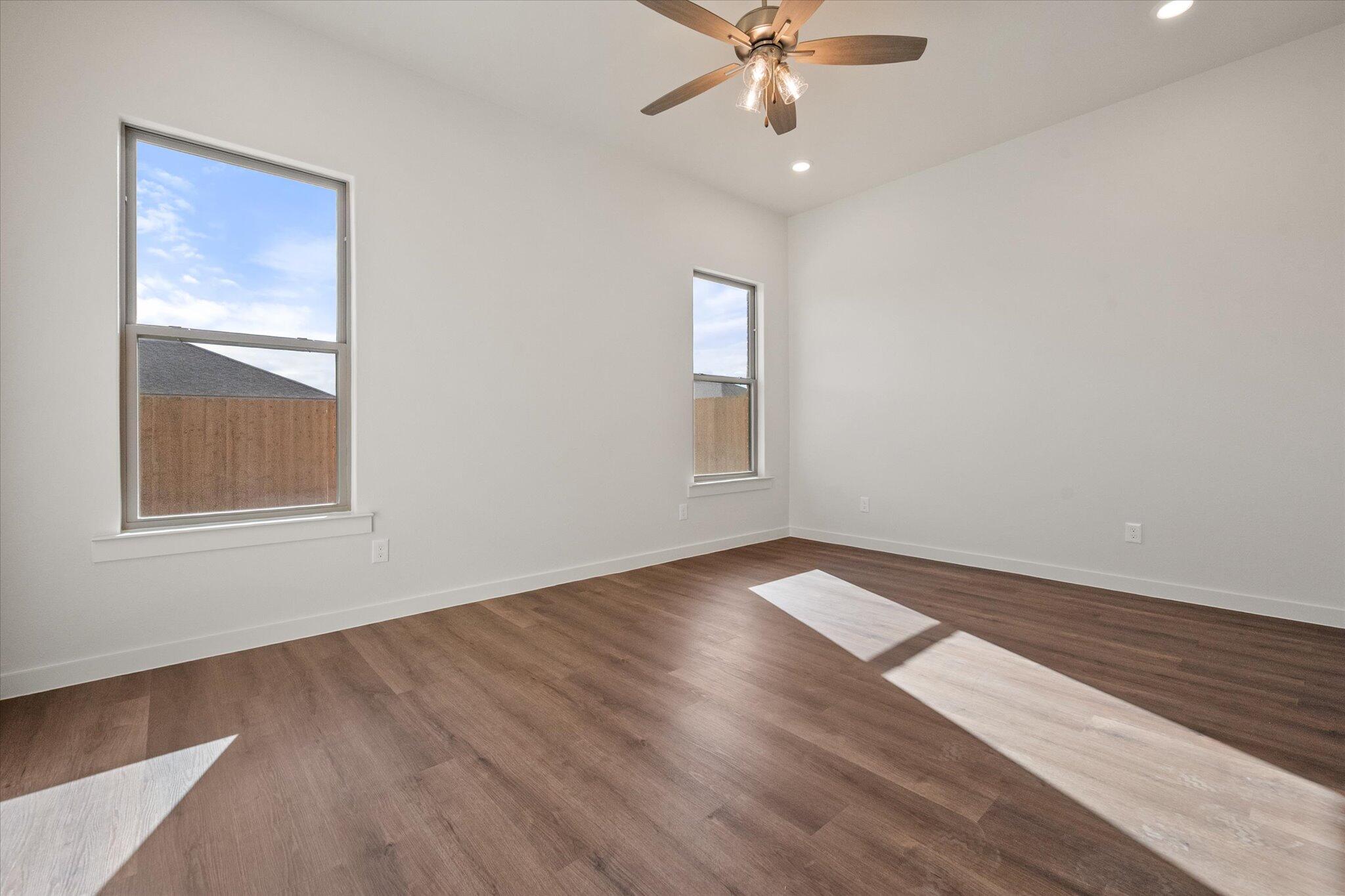 7207 7th Street Lubbock, TX 79416 - Photo 12 of 22 a view of an empty room with wooden floor and a window