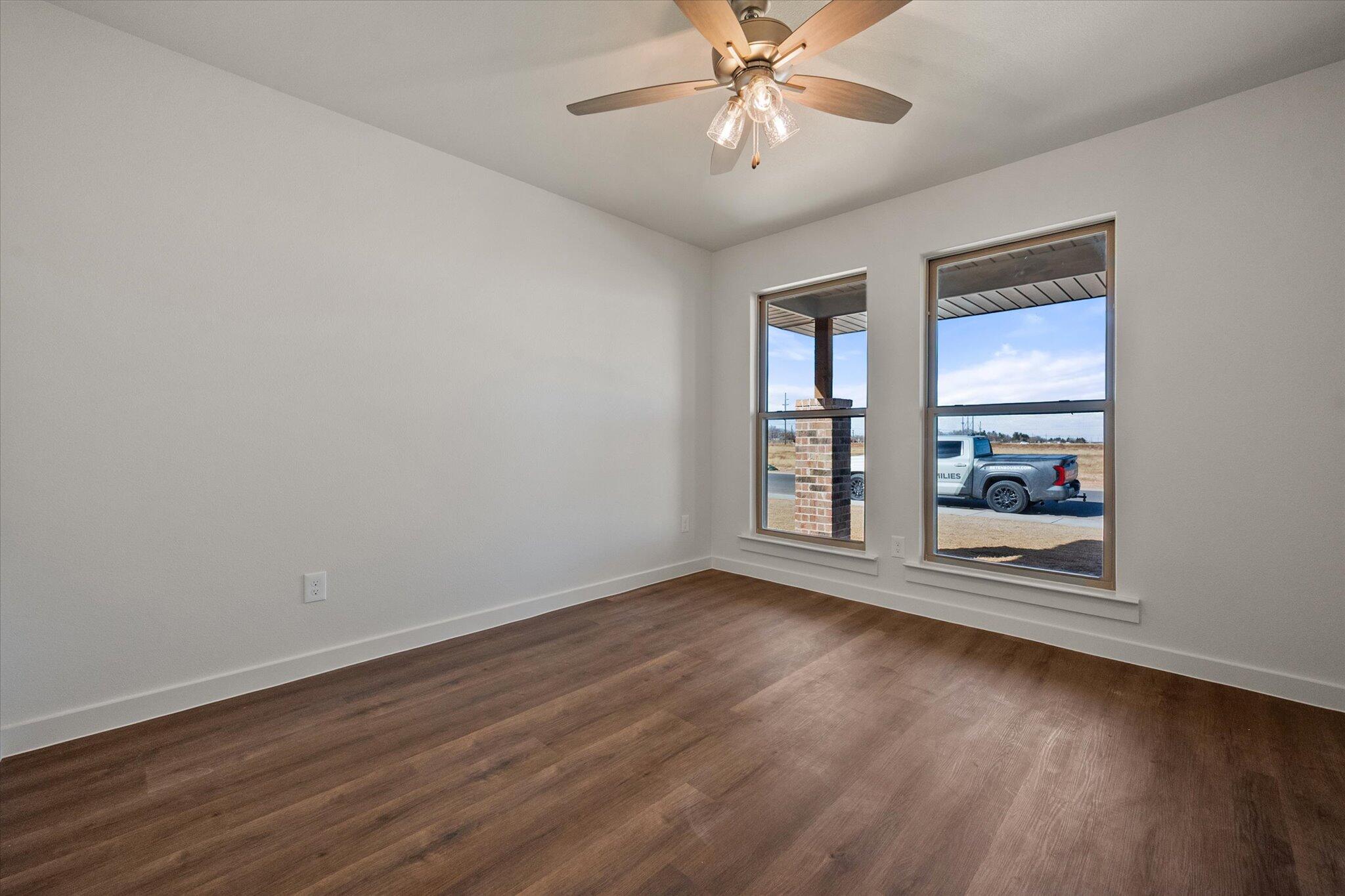 7207 7th Street Lubbock, TX 79416 - Photo 16 of 22 a view of an empty room with wooden floor and a window