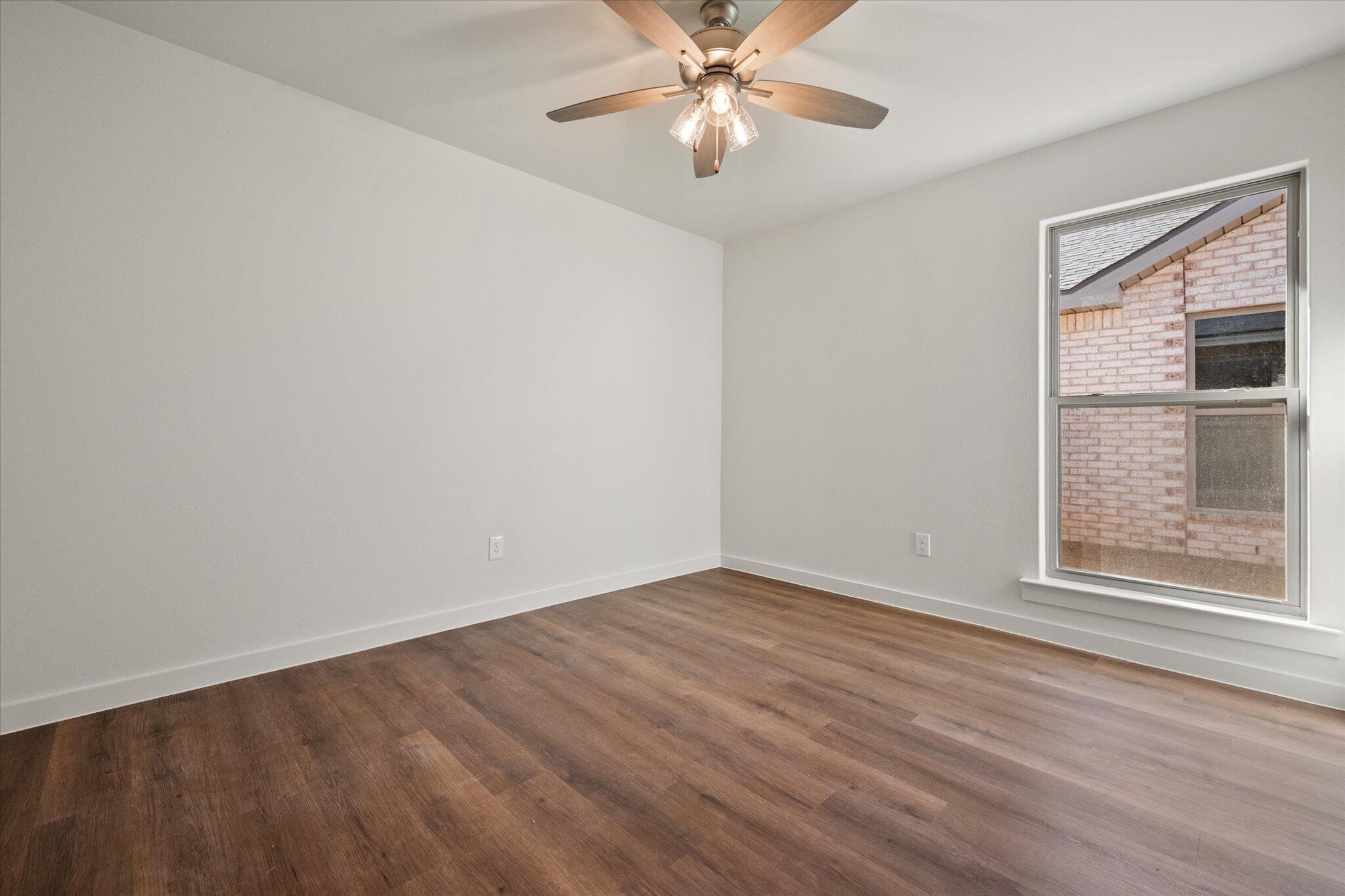 7207 7th Street Lubbock, TX 79416 - Photo 20 of 22 wooden floor in an empty room with a window