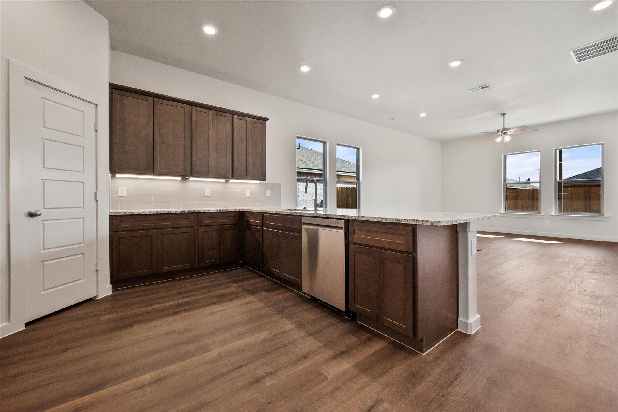 7207 7th Street Lubbock, TX 79416 - Photo 3 of 22 a kitchen with stainless steel appliances granite countertop a stove a sink and a refrigerator