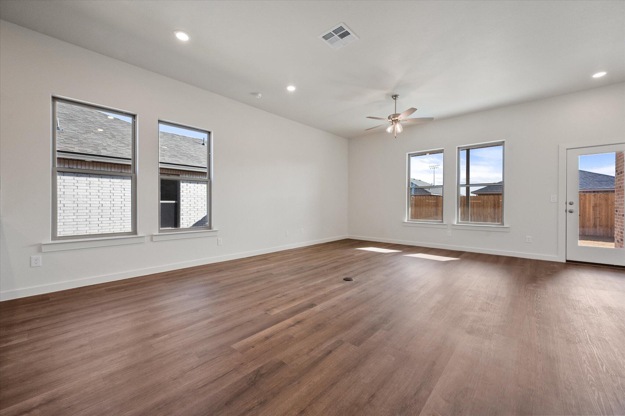 7207 7th Street Lubbock, TX 79416 - Photo 7 of 22 wooden floor in an empty room with a window