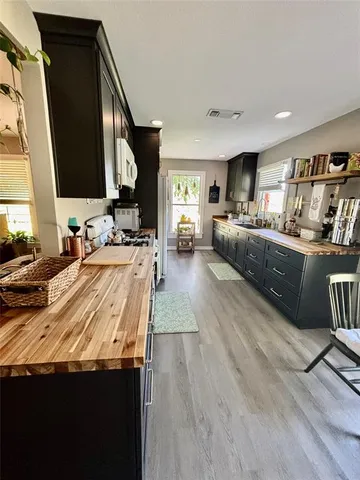 a kitchen with stainless steel appliances kitchen island granite countertop a sink dishwasher stove and wooden cabinets