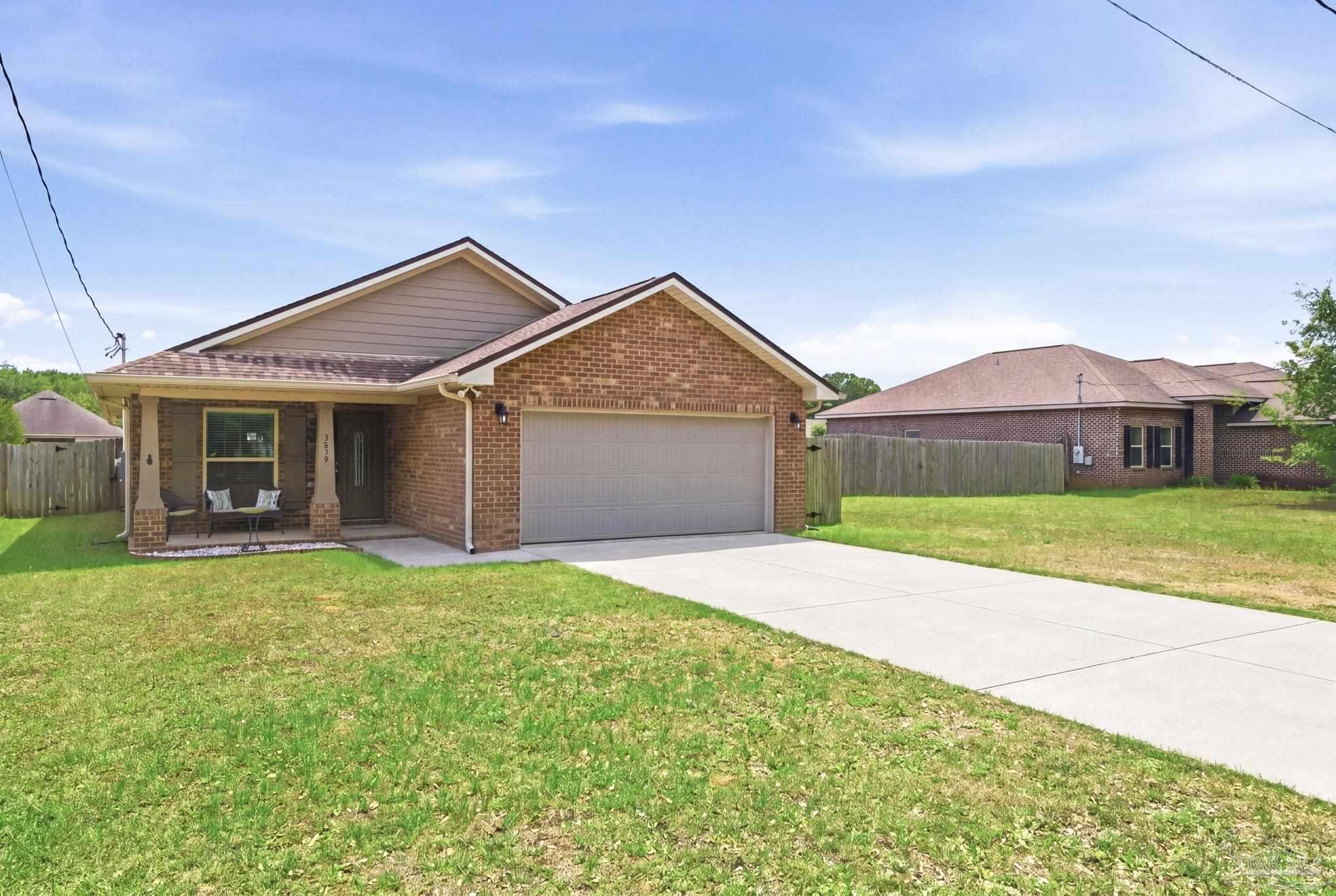 3859 Adams Road Pace, FL 32571 - Photo 4 of 26 a front view of a house with a garden and yard