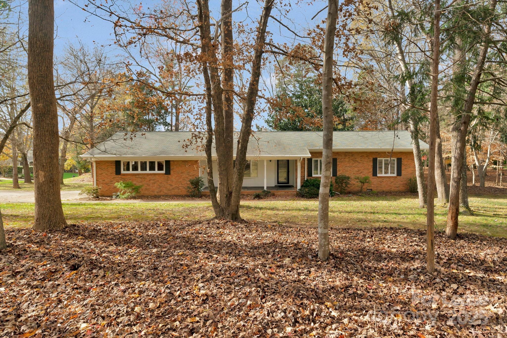 a view of a house with a yard and large tree