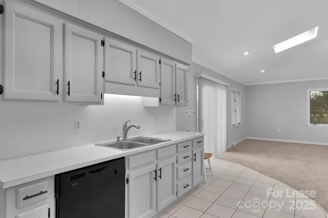 a kitchen with white cabinets and sink