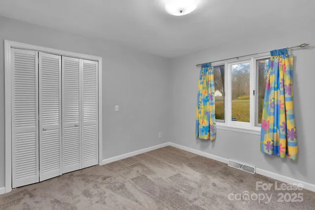 an empty room with furniture and a flat screen tv