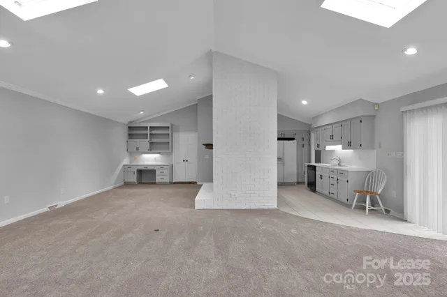 a view of a kitchen with furniture and a refrigerator