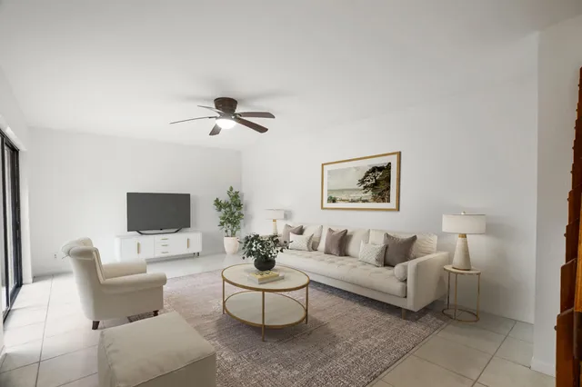 a living room with furniture a rug and a ceiling fan