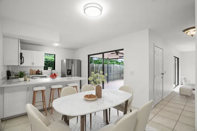 a view of a dining room and kitchen with a table and chairs