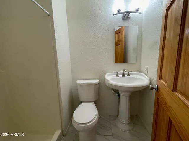 a bathroom with a toilet sink and mirror