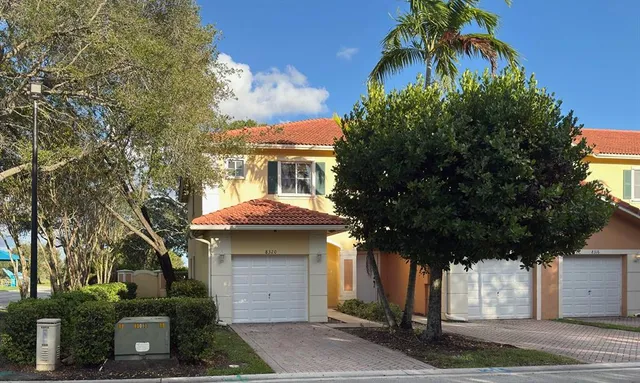 a front view of a house with a tree