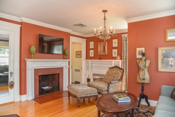 a living room with furniture a fireplace and a chandelier