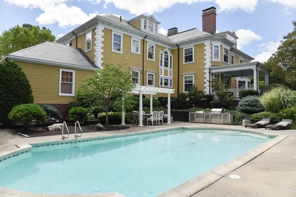 a view of a house with pool and chairs