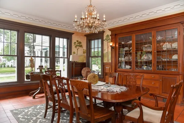 a dining room with furniture a chandelier and wooden floor