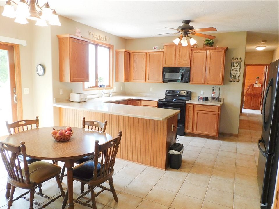 3265 Bloods Point Road Kirkland, IL 60146 - Photo 2 of 35 a kitchen with a dining table chairs and a refrigerator