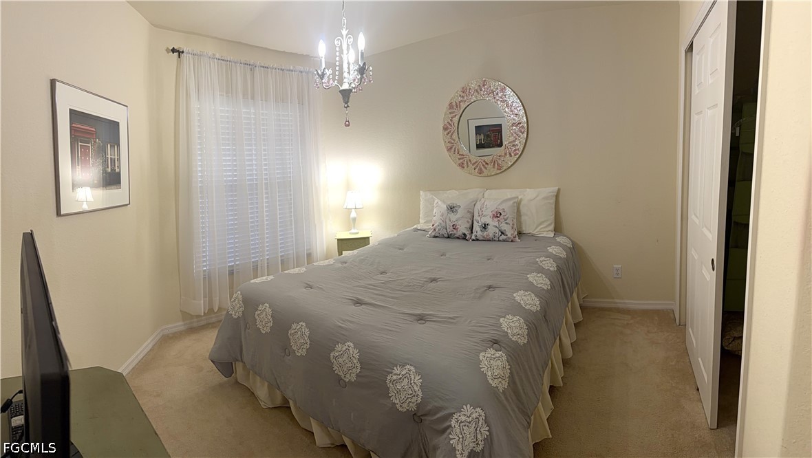 19674 Villa Rosa Loop Estero, FL 33967 - Photo 13 of 33 a bedroom with a bed and a chandelier