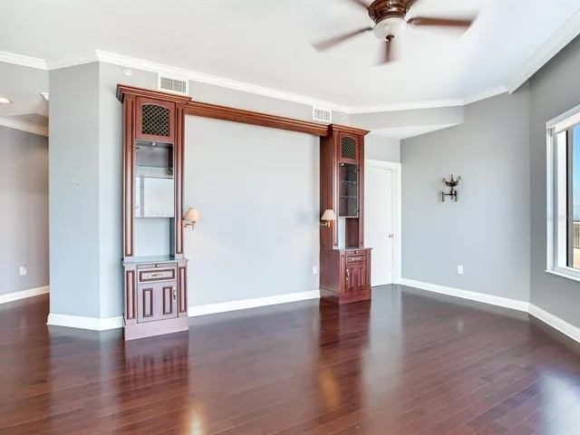 a view of a hallway with wooden floor and a ceiling fan