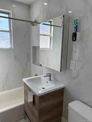 a bathroom with a sink and mirror with toilet