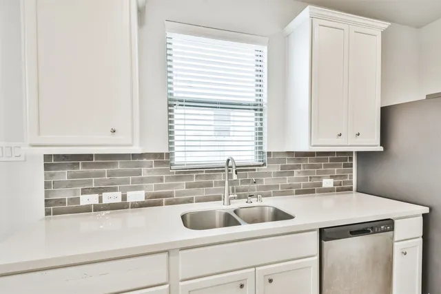 a kitchen with white cabinets stainless steel appliances and sink