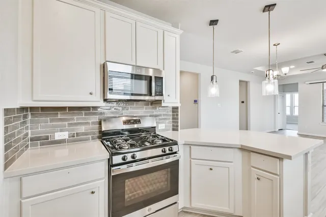 a kitchen with kitchen island a sink appliances and cabinets