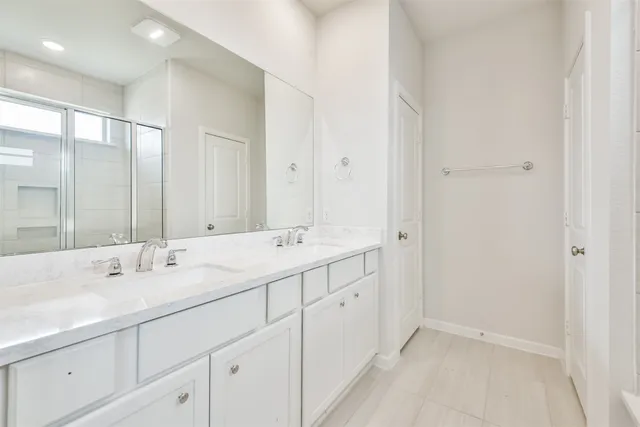 a bathroom with a glass shower door and a glass door
