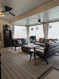 a living room with furniture a flat screen tv and a table