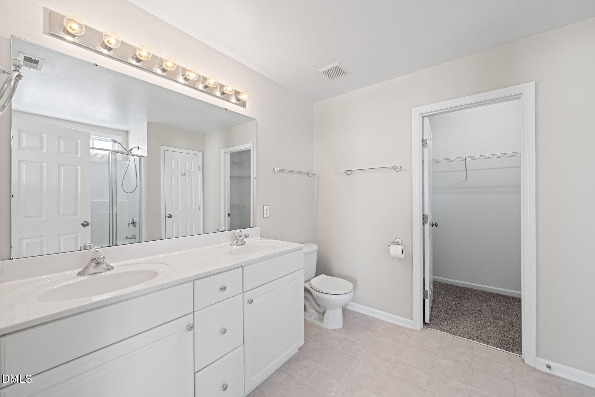 4112 Bay Rum Lane Raleigh, NC 27610 - Photo 25 of 43 a spacious bathroom with a double vanity sink a mirror and a toilet