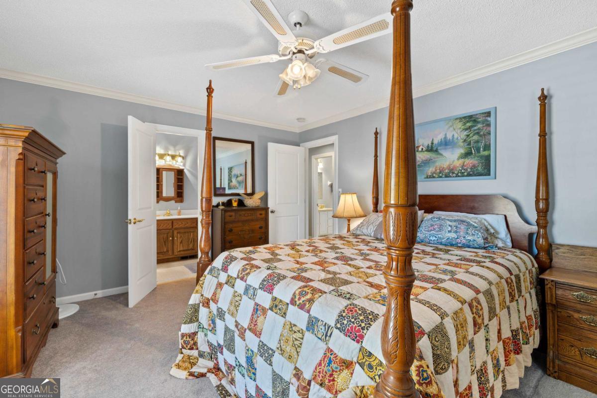 1320 Tal Lewis Road White Plains, GA 30678 - Photo 12 of 19 a bedroom with a bed and a chandelier