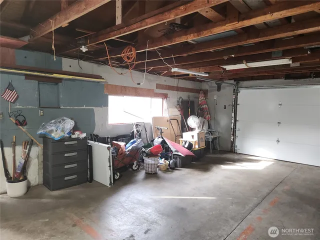 a view of a hallway with wooden floor and a bathroom