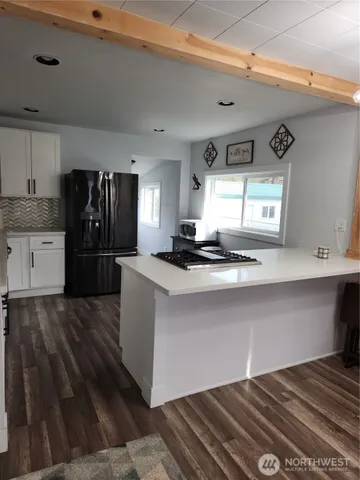 a kitchen with granite countertop a sink stove and cabinets