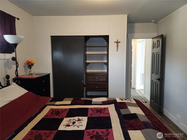 a view of a hallway to a livingroom and a chair