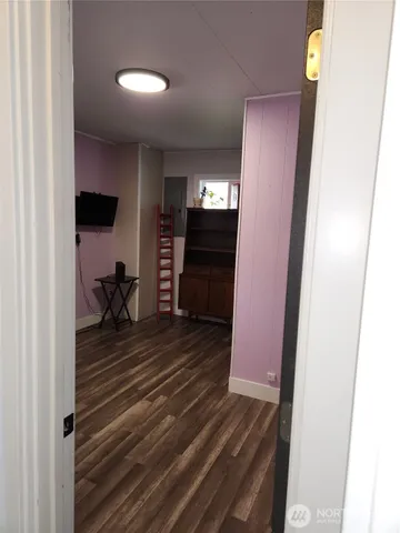 a view of empty room with wooden floor and stairs