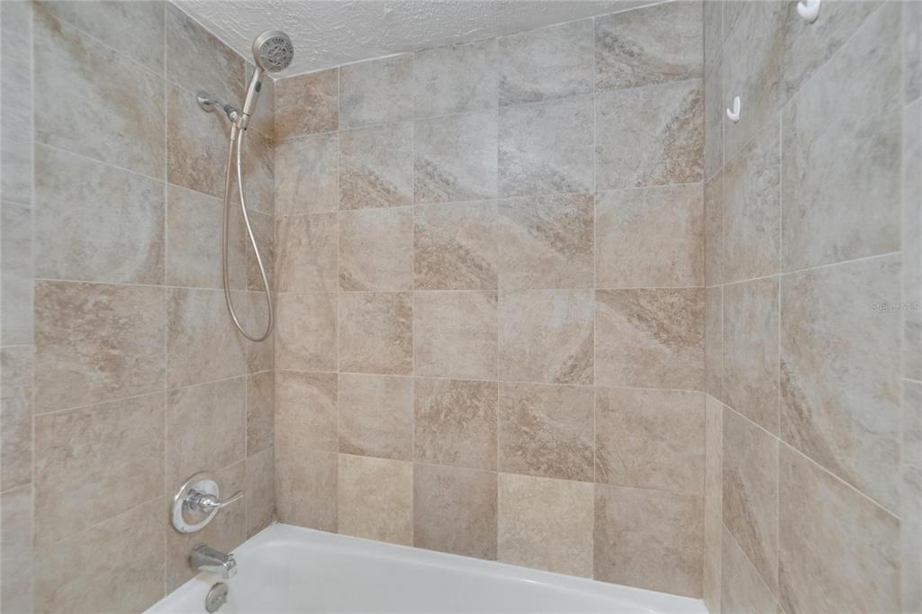 125 Picardy Villa Circle, Unit 100 Brandon, FL 33510 - Photo 18 of 52 a bathroom with a shower and toilet