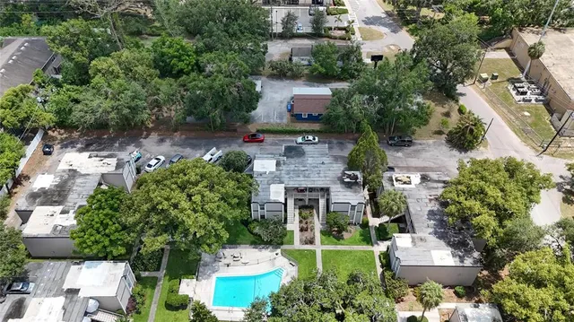 an aerial view of a house with lots of trees and houses