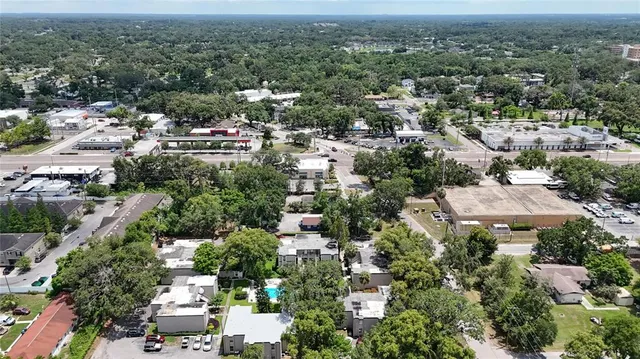 an aerial view of a residential houses with outdoor space and trees